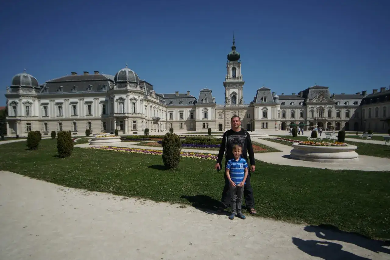 Ojciec z synem na tle pałacu Festetics, jednej z głównych keszthely atrakcji. Piękny ogród i błękitne niebo.