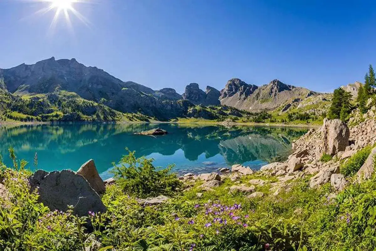 Magnifique lac d'altitude aux reflets turquoise, entouré de montagnes majestueuses. Idéal pour des vacances montagne été paisibles et ressourçantes.