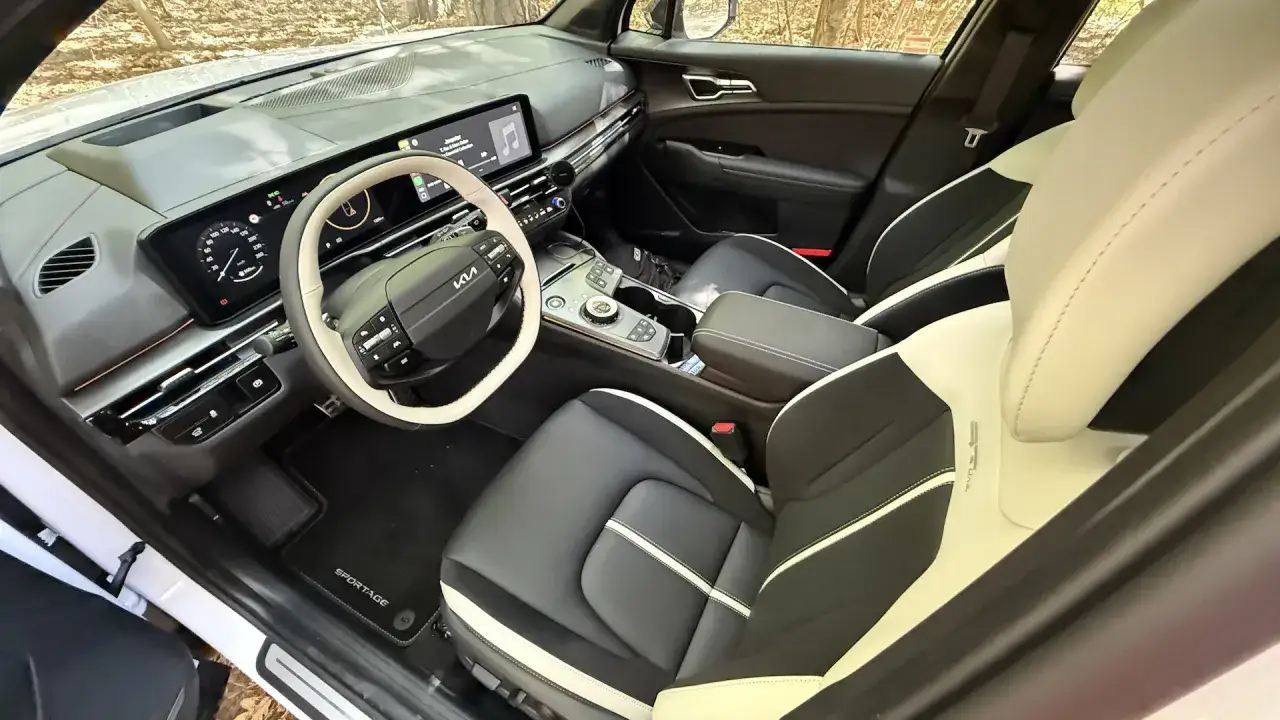 Wnętrze Kia Sportage GT Line z dwukolorową tapicerką, nowoczesnym panelem i kierownicą.