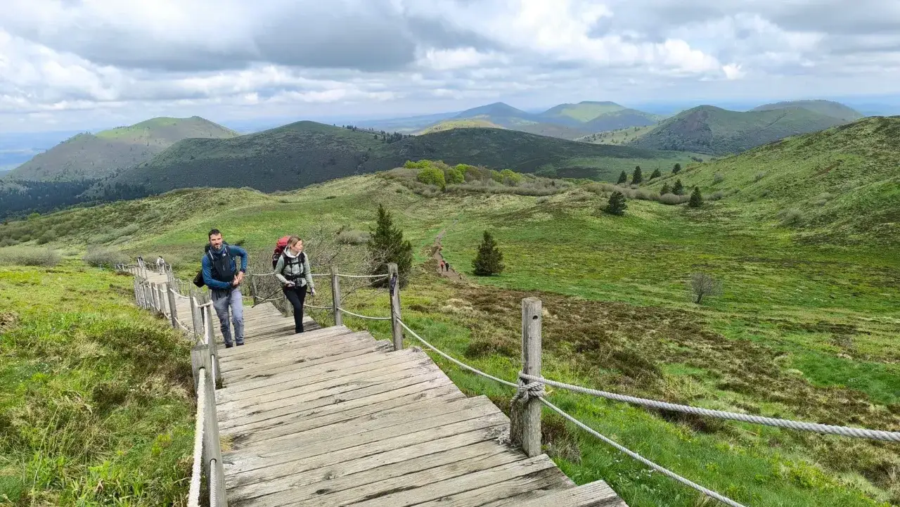 Randonneurs sur un escalier en bois, paysage de volcans verdoyants, gr 441.
