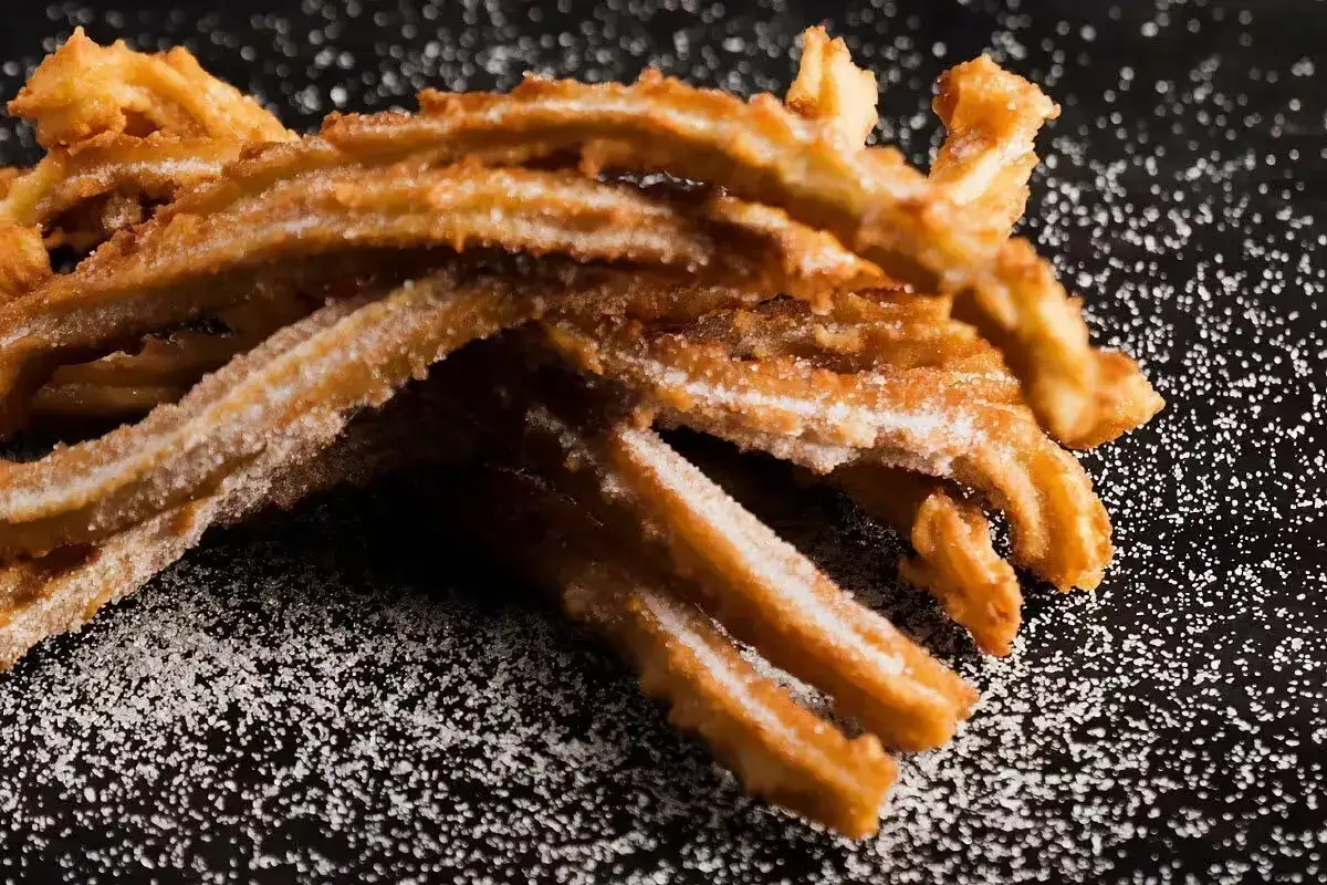 Churros co to? Złociste, chrupiące paluszki smażone w głębokim tłuszczu, posypane cukrem. Idealne na deser.