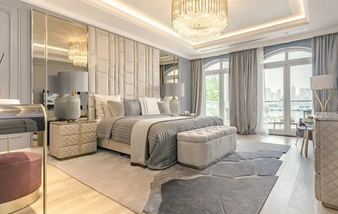 Sypialnia glamour inspiracje: luksusowe ł&oacute;żko, pikowane zagłowie, kryształowy żyrandol, lustra i eleganckie meble tworzą wyrafinowaną atmosferę.