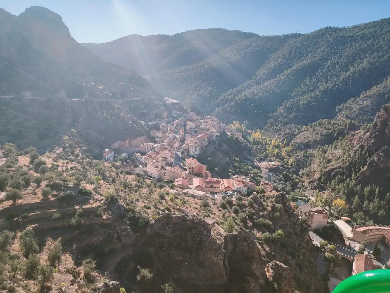 Pueblo encajado en un valle montañoso, con casas de tejados rojos y vegetación. Descubre qué ver en Ayna, un rincón pintoresco.