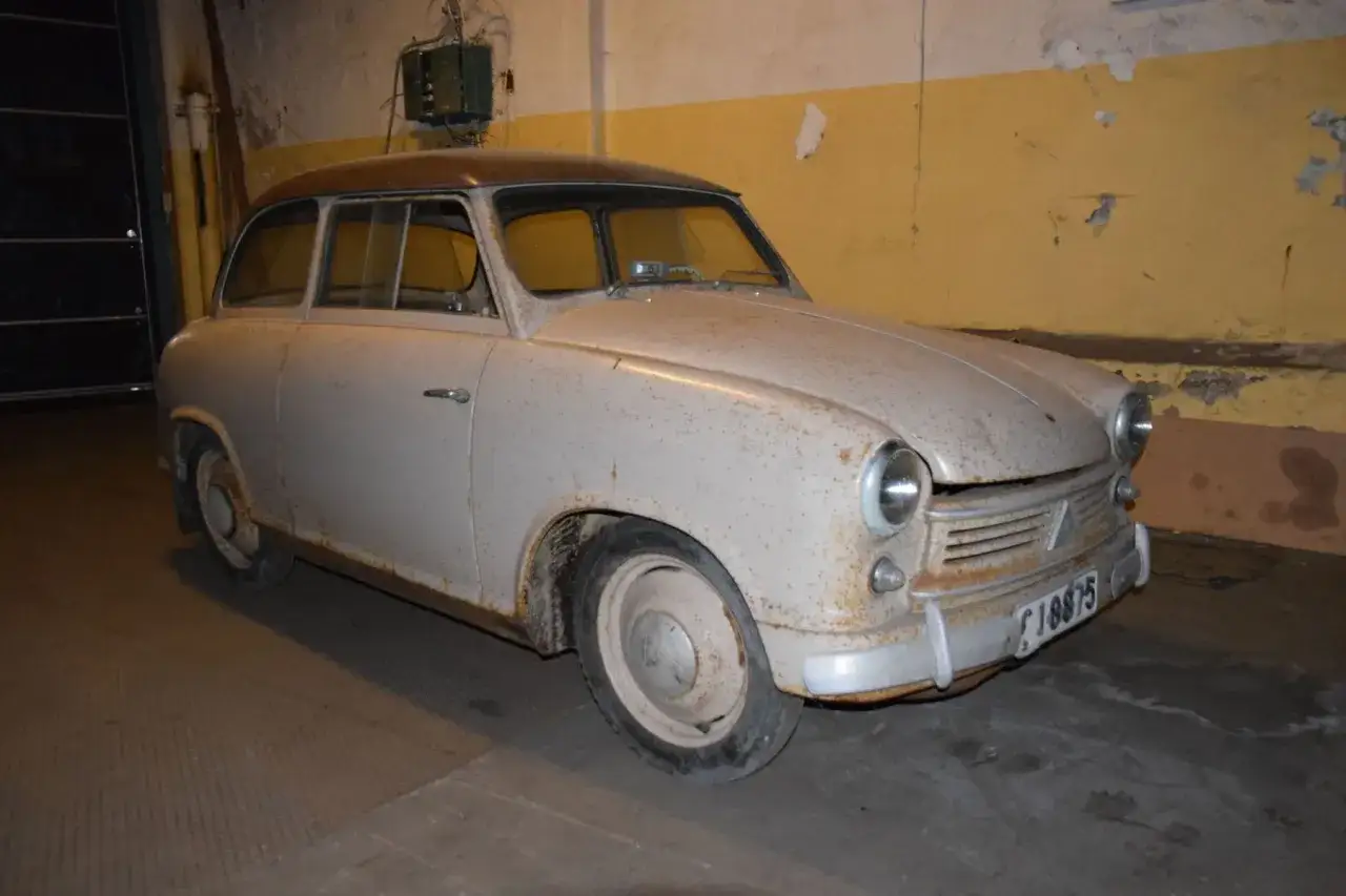En rostig lloyden bil st&aring;r i ett garage.