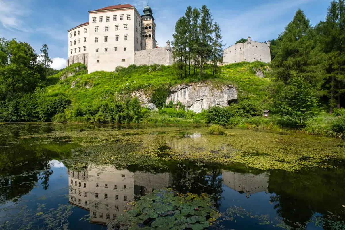 Zamek na skale, odbijający się w stawie, to idealne miejsce, by zobaczyć, co zwiedzić w Małopolsce.