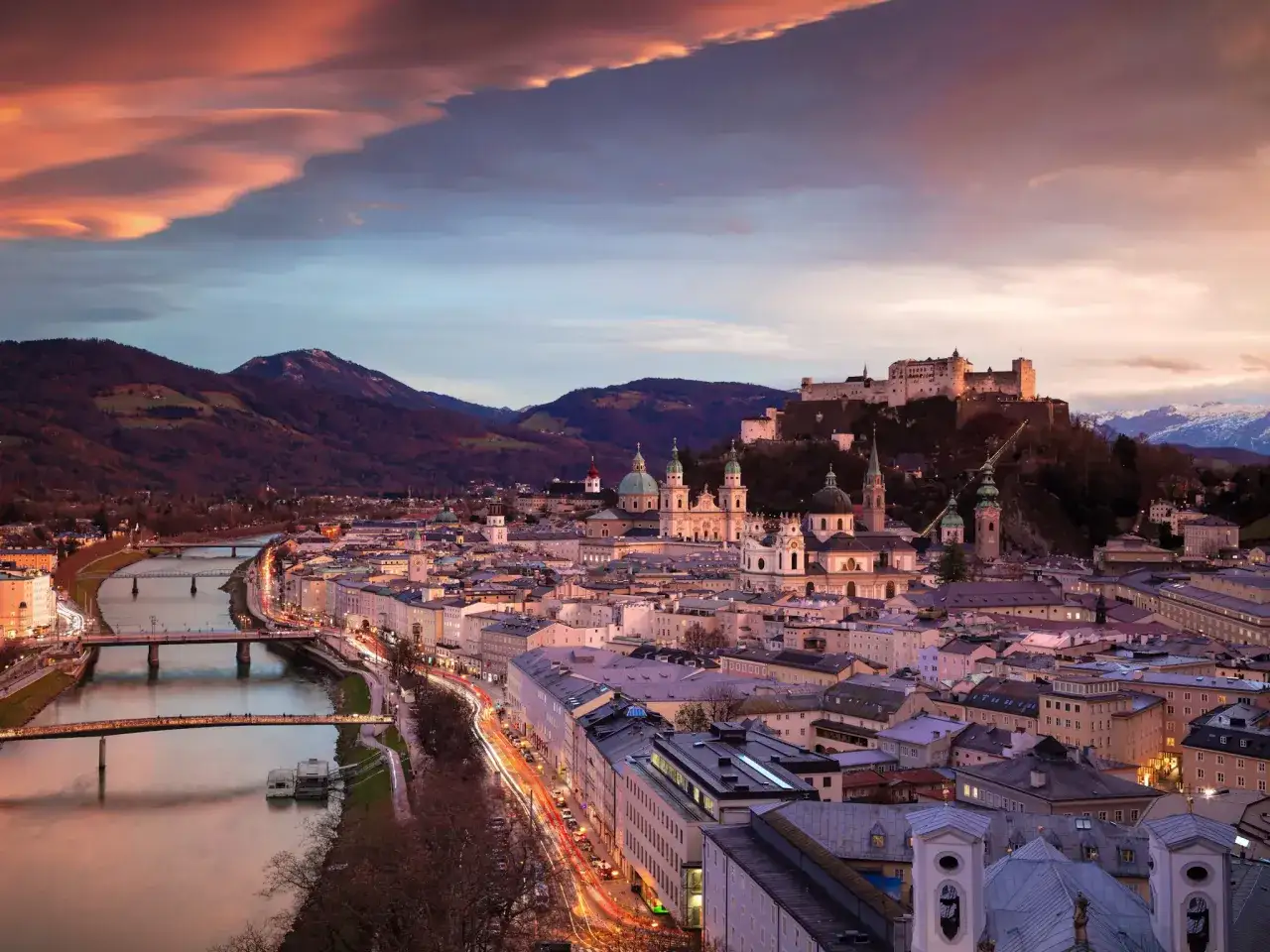 Salzburgs f&auml;stning tronar &ouml;ver staden vid solnedg&aring;ngen. En dr&ouml;m f&ouml;r alla som s&ouml;ker billiga resm&aring;l i Europa.