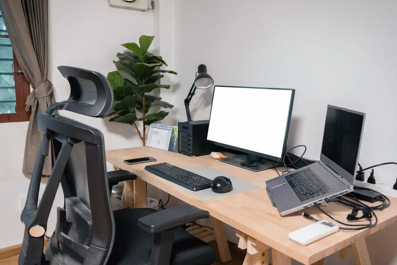 Ergonomiczne biurko z monitorem, laptopem i wygodnym fotelem. Idealna wysokość biurka zapewnia komfort pracy.