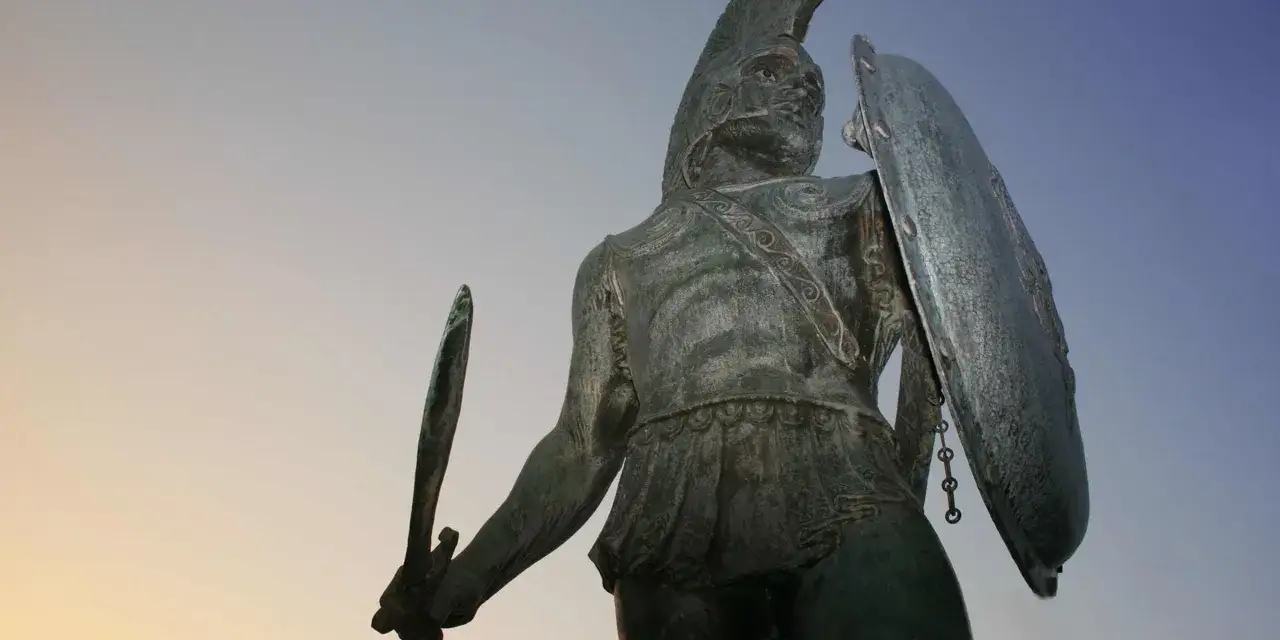 Bronzestatue eines spartanischen Kriegers mit Helm, Schild und Schwert. Die spartanische Bedeutung von Einfachheit und Disziplin wird durch die Statue verk&ouml;rpert.