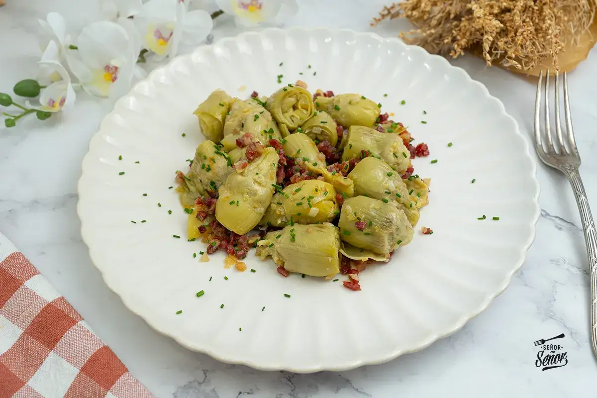 Alcachofas de bote salteadas con jamón y cebolla, un plato sencillo y delicioso. ¡Perfecto para tus recetas con alcachofas de bote!