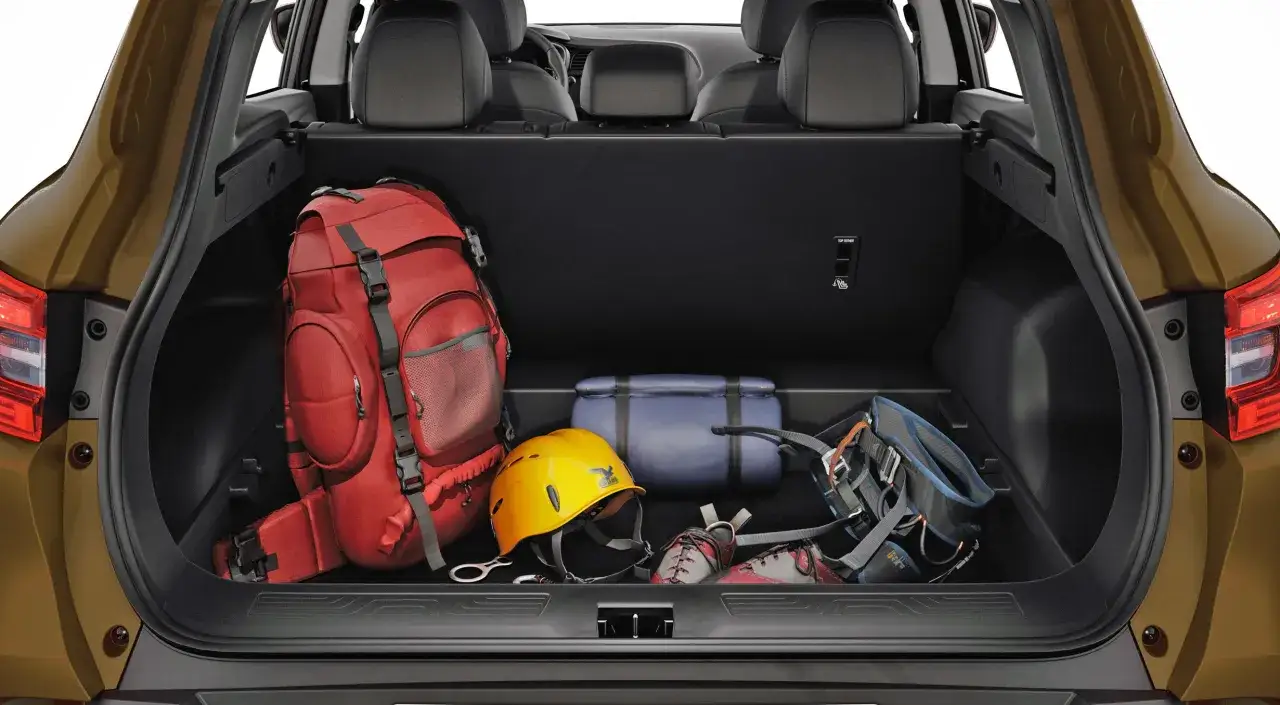 Le volume coffre Kadjar est prêt pour l'aventure : sac à dos rouge, casque jaune, chaussures d'escalade et baudrier.