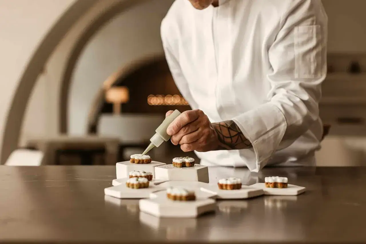Chef decora postres en un restaurante con estrellas Michelin. La precisi&oacute;n y el arte culinario se unen para crear experiencias gastron&oacute;micas inolvidables.