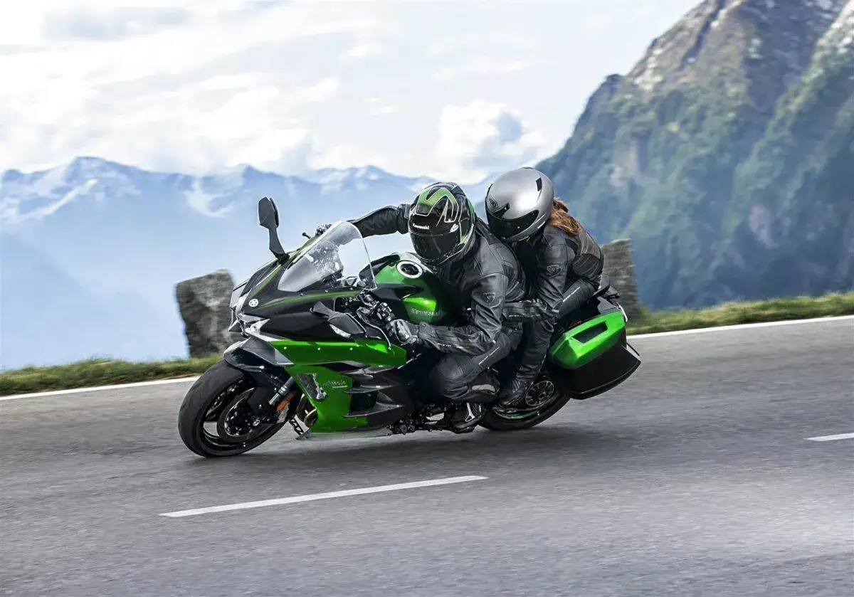 Pareja disfrutando de motos para viajar en pareja por carreteras montañosas.