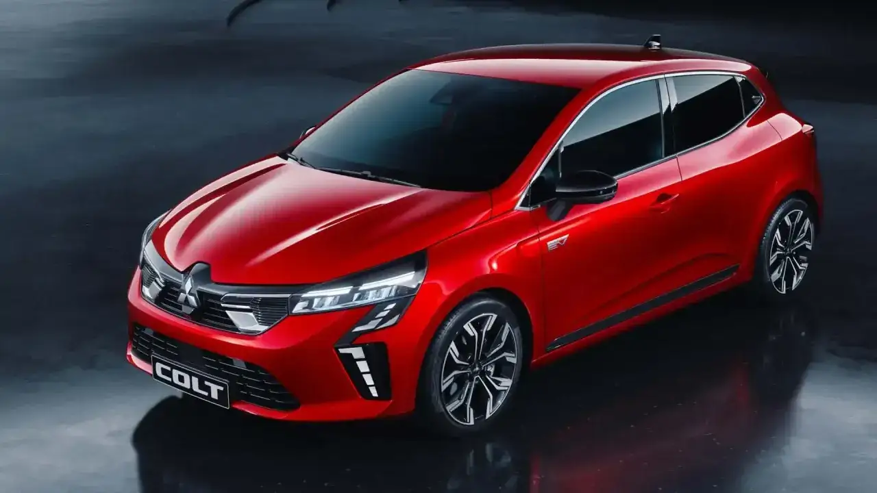 Nowy, czerwony Mitsubishi Colt błyszczy na ciemnym tle. Elegancki design i nowoczesne światła podkreślają jego sportowy charakter.