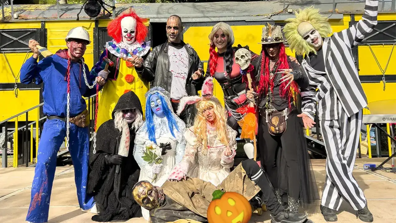Grupo de personas disfrazadas para Halloween en Zaragoza. Hay un payaso, un hombre con traje de rayas y otros personajes terroríficos.