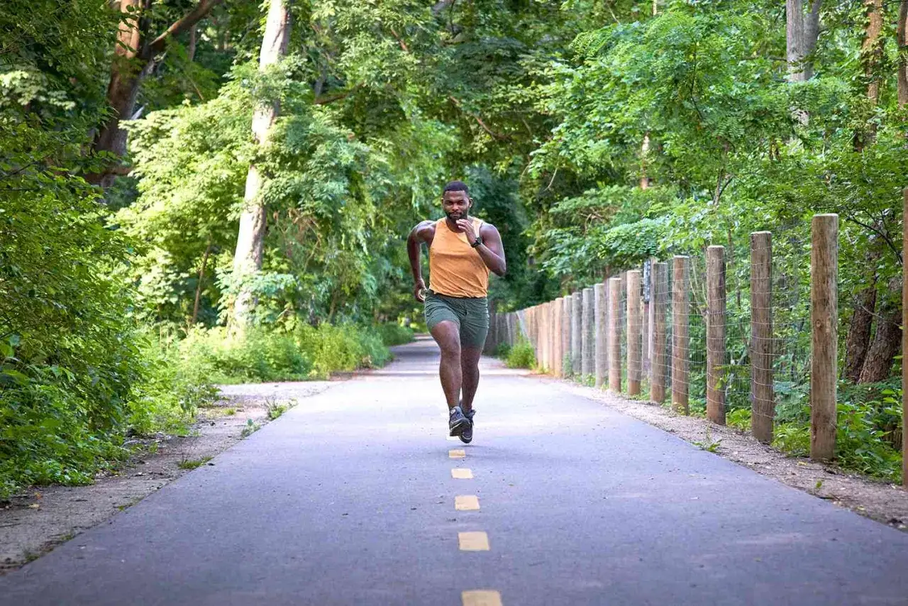 Mann läuft auf einem Waldweg, die Vorbereitung für den Halbmarathon läuft.