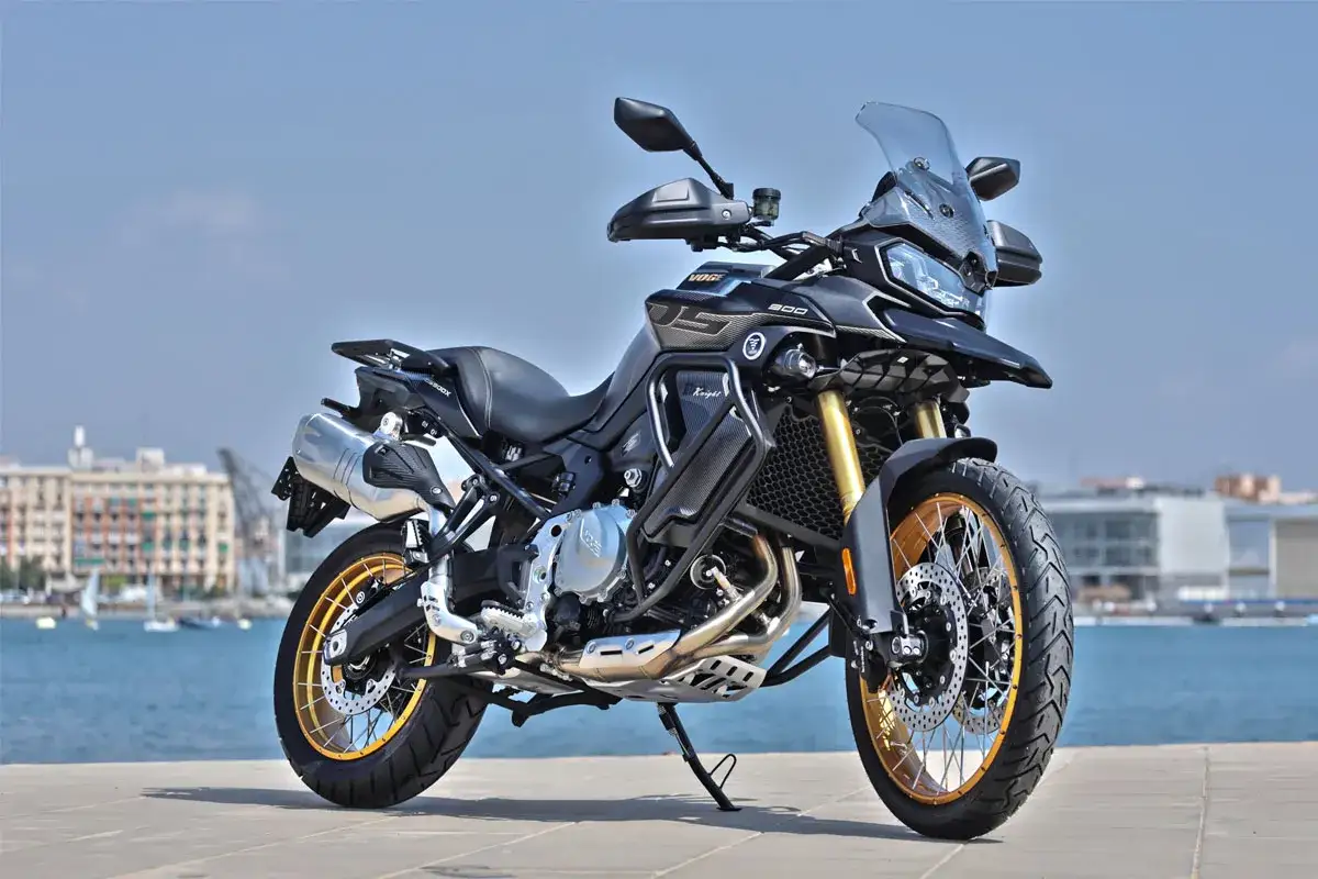 Aventura en moto china con motor BMW. Esta VOGE 500DS negra y dorada, lista para explorar la costa.