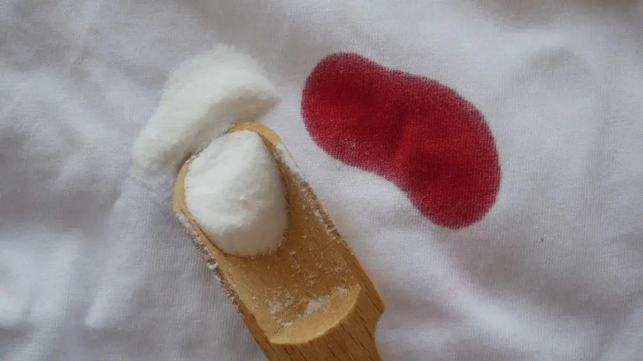 Poudre blanche sur tissu blanc &agrave; c&ocirc;t&eacute; d'une tache rouge. Astuce pour savoir comment enlever une tache de sang d&eacute;j&agrave; lav&eacute;.