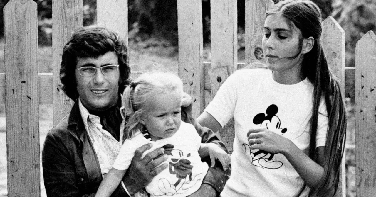 Al Bano z rodziną, trzymający jedno ze swoich dzieci. Wszyscy w koszulkach z Myszką Miki.