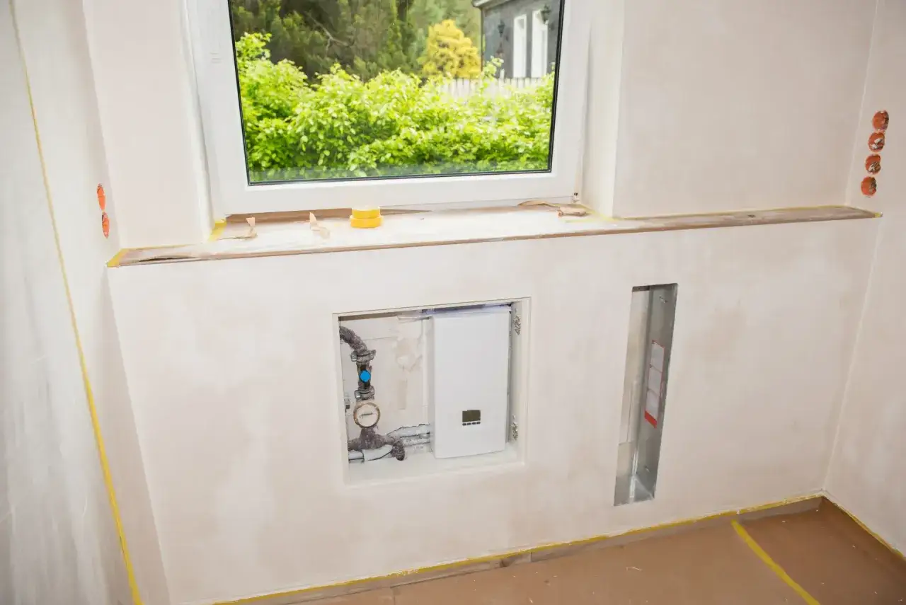 Einbau eines modernen, **durchlauferhitzer g&uuml;nstig** im Nischenbereich unter dem Fenster. Installation in einem frisch verputzten Raum.