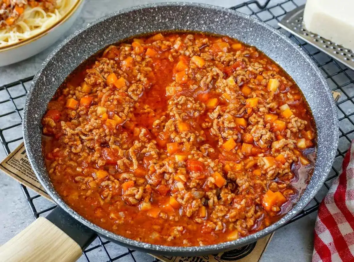 Herzhaftes Bolognese-Rezept einfach zubereitet: Hackfleisch, Karotten und Tomaten köcheln in der Pfanne. Perfekt für Pasta!
