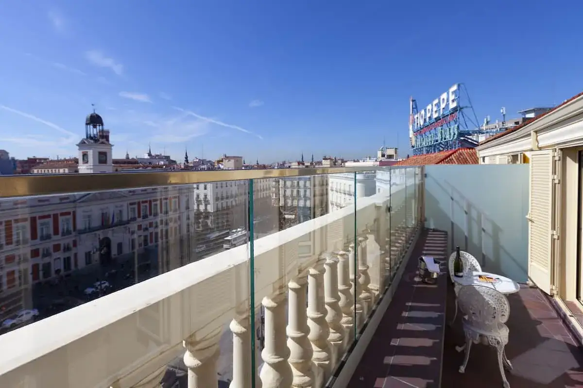 Terraza del Hotel Europa con vistas a la Puerta del Sol, Madrid. Mesa con sillas y botella de cava.
