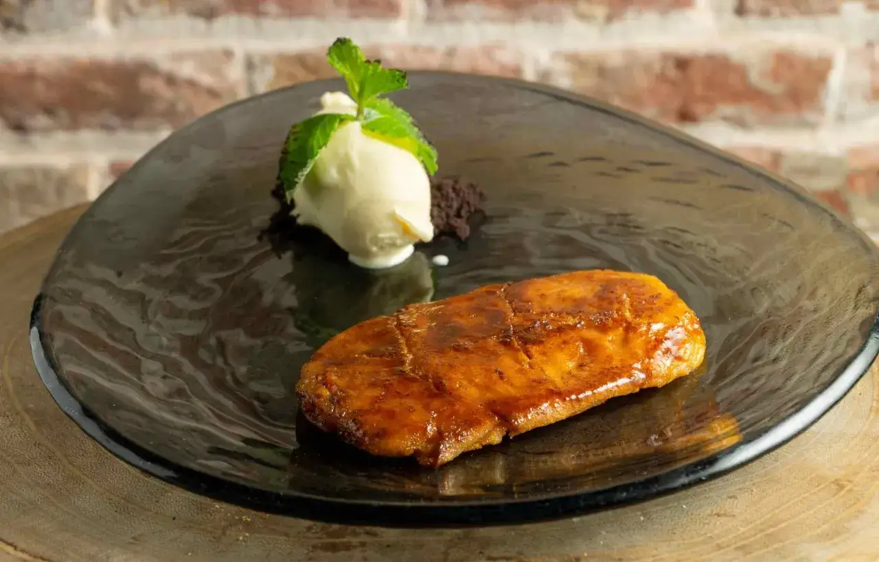 Torrijas de Semana Santa caramelizadas, servidas con helado de vainilla y menta fresca.