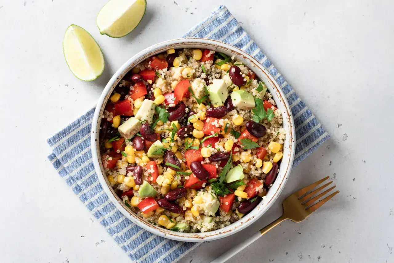 Ensalada vibrante de quinoa con frijoles rojos, maíz, aguacate y pimientos. Una de las mejores quinoa recetas para una comida saludable.