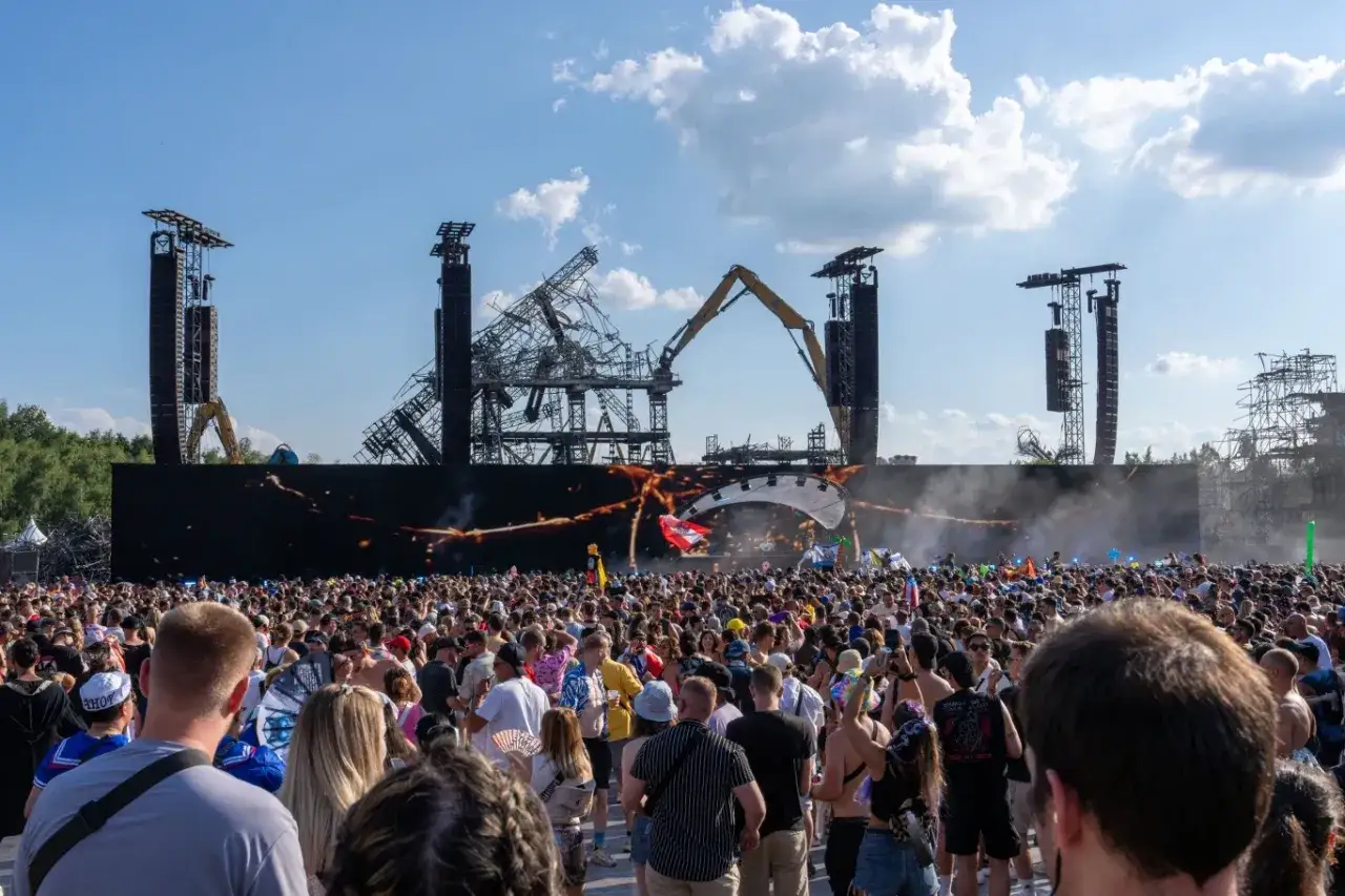 Tłum ludzi na festiwalu, w tle scena z konstrukcją i ekranem. Już czuć atmosferę Tomorrowland 2026!