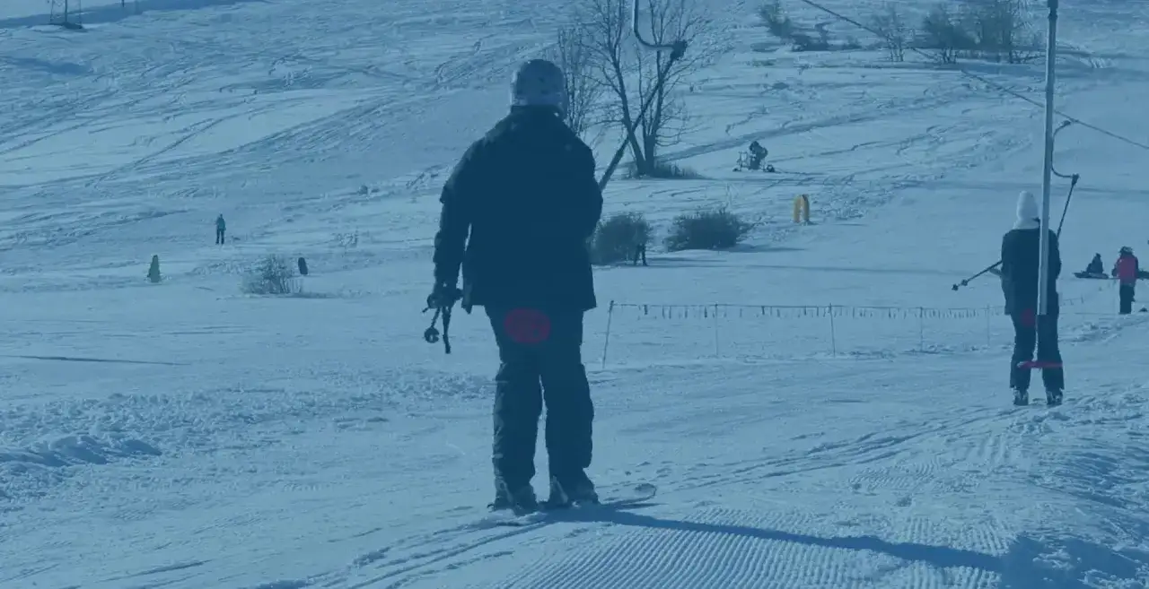Narciarz czeka na wyciąg narciarski Horników Wierch u Goryla, gotowy do zjazdu po ośnieżonym stoku.