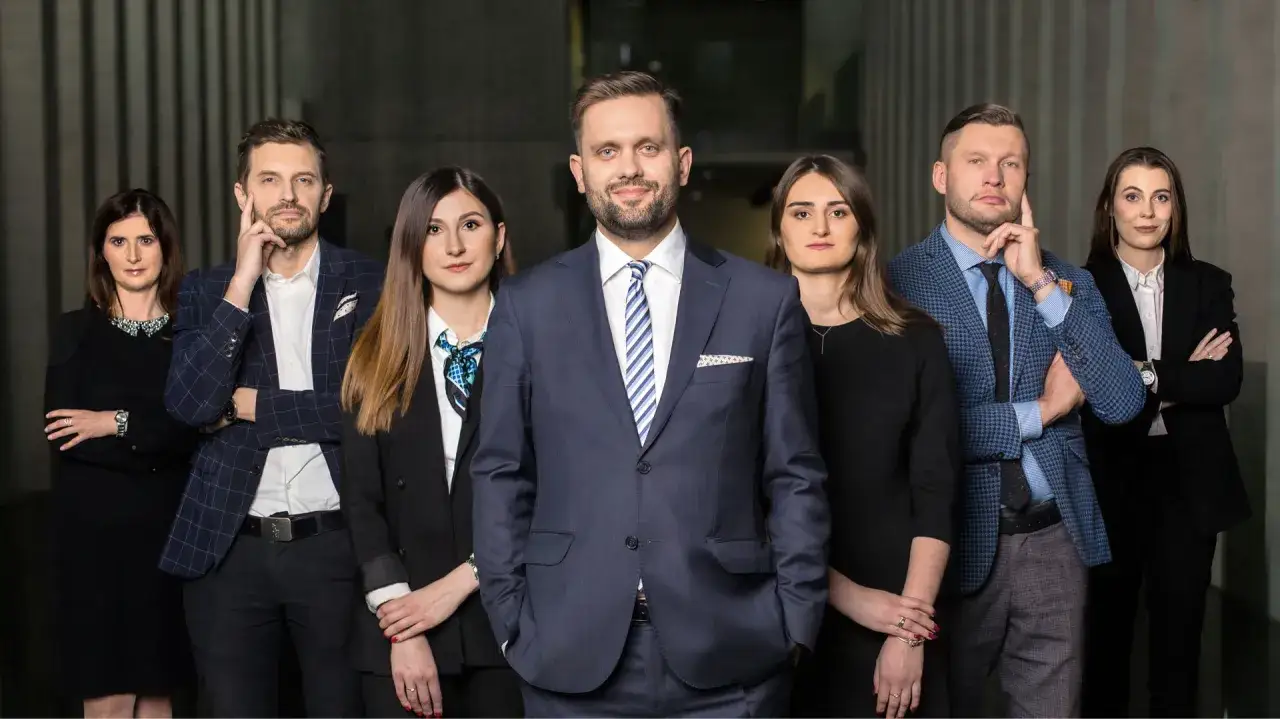 Grupa profesjonalistów w eleganckich strojach. Czy to zespół prawników, którzy mogą być Twoim mecenasem?