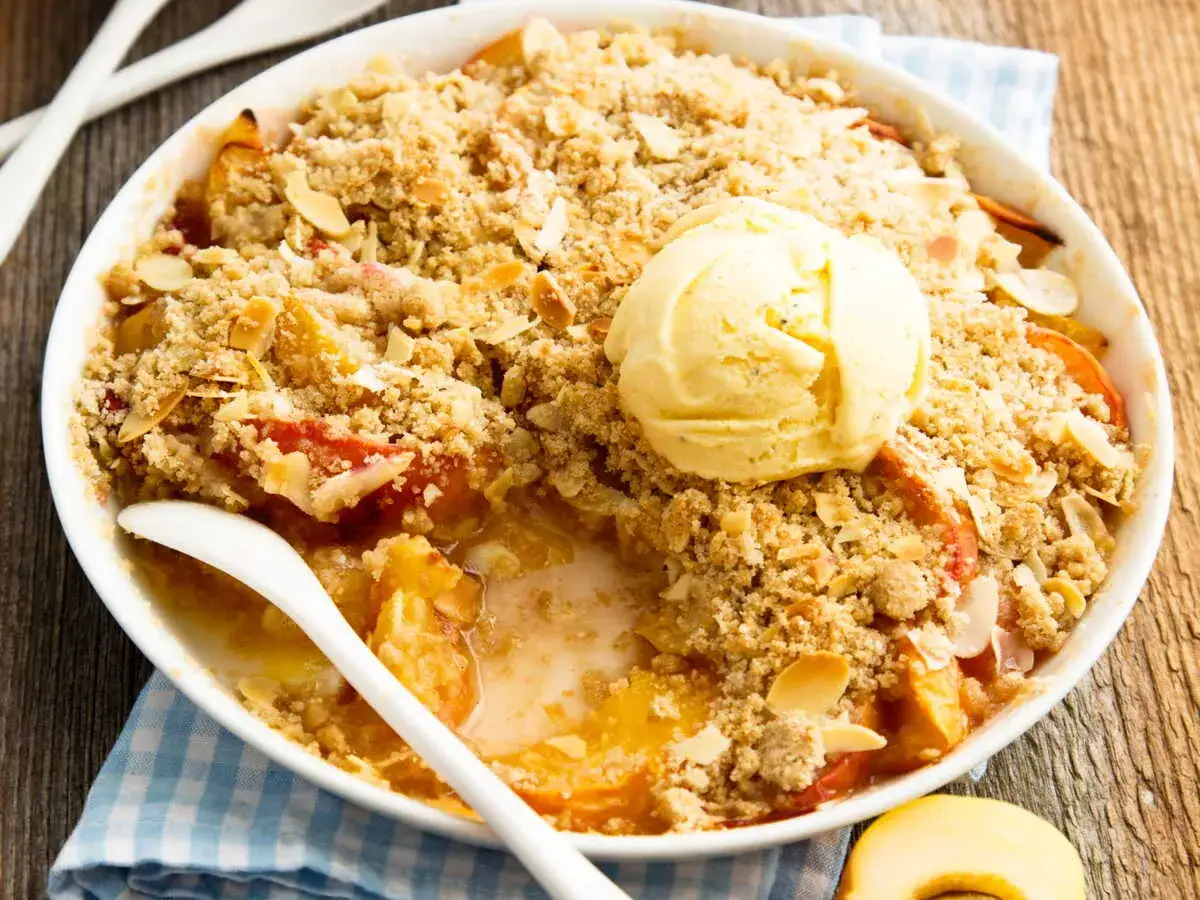 Un d&eacute;licieux crumble abricot, garni d'une boule de glace &agrave; la vanille, pr&ecirc;t &agrave; &ecirc;tre d&eacute;gust&eacute;.