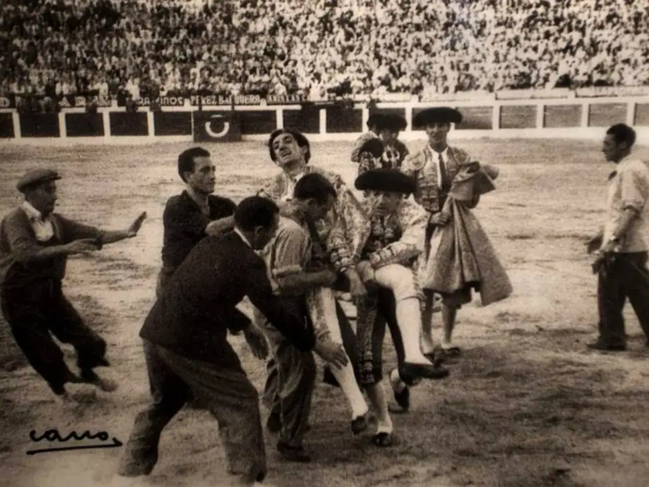 En la plaza, tras la tragedia, se preguntan qui&eacute;n mat&oacute; a Manolete. El torero es llevado en brazos, rodeado de gente.