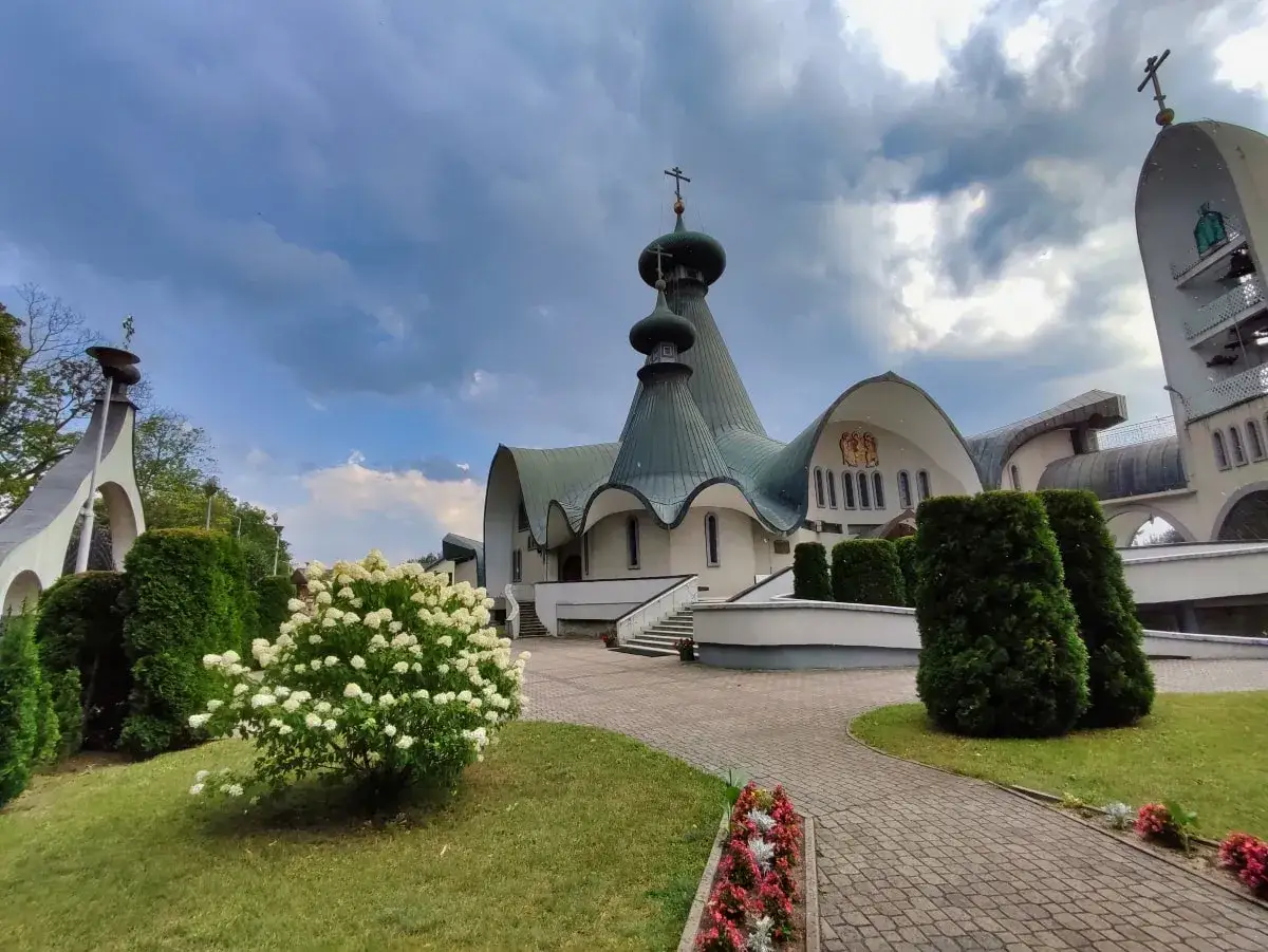 Cerkiew prawosławna w Hajnówce, jedna z głównych atrakcji, z zielonymi kopułami i kwitnącą hortensją.