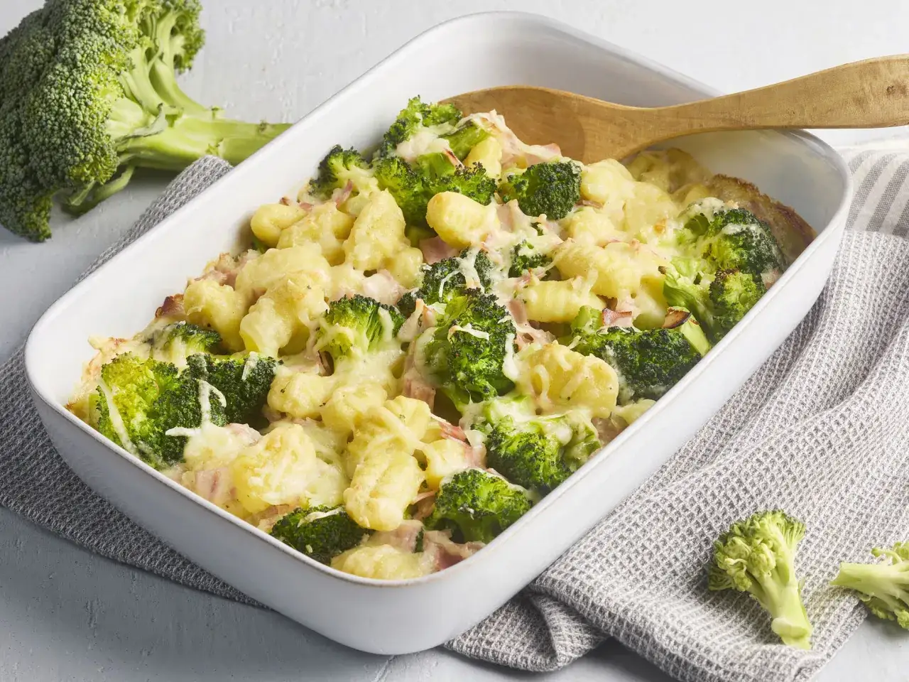 Ein herzhafter Brokkoli Gnocchi Auflauf mit Schinken und geschmolzenem K&auml;se, bereit zum Servieren.