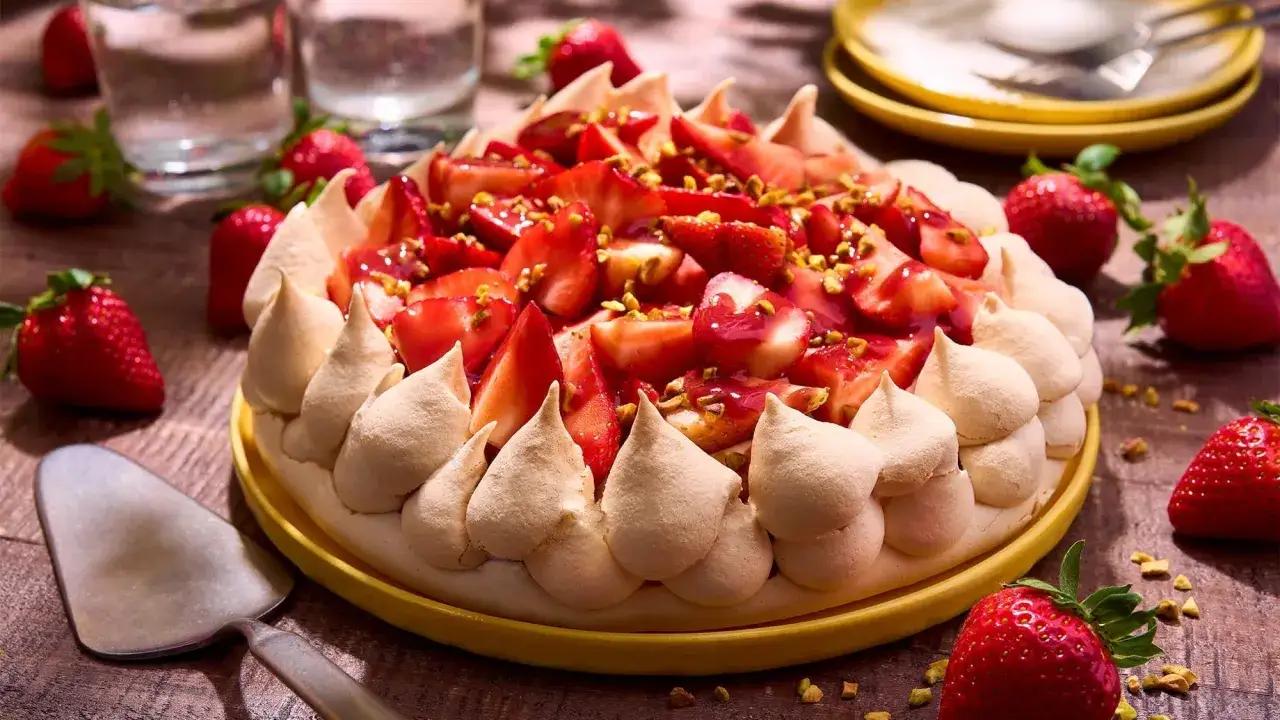 Pavlova fraise, une meringue a&eacute;rienne garnie de fraises fra&icirc;ches, de coulis et de pistaches concass&eacute;es. Un d&eacute;lice estival.