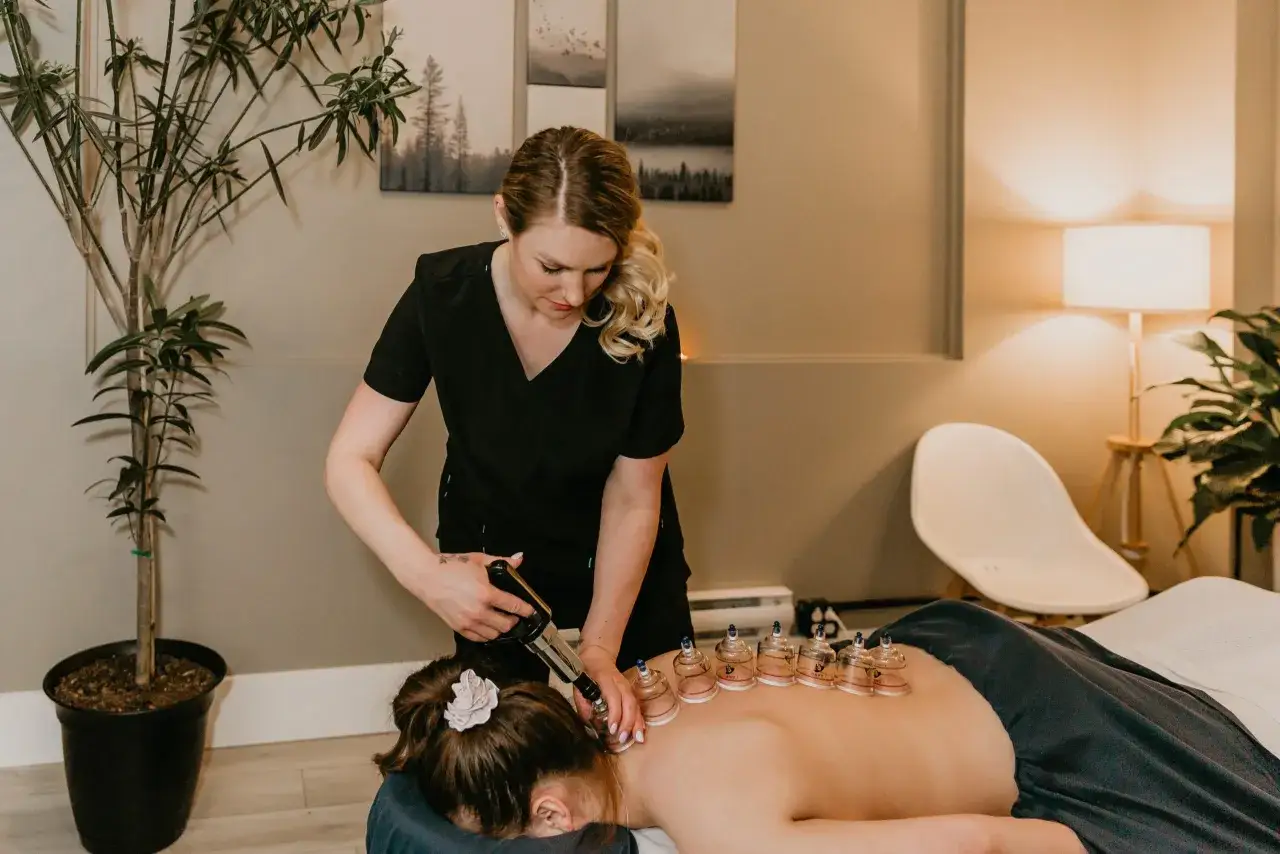 Therapeutin wendet Schröpfgläser an. Informieren Sie sich über Massage und Physiotherapie Kosten für Ihre Behandlung.