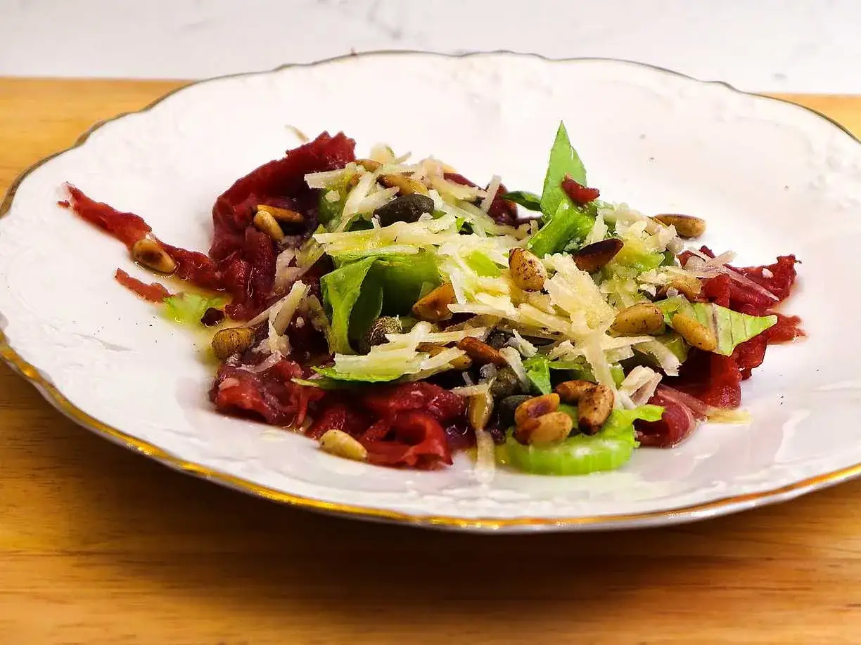 En elegant carpaccio med tunt skivad oxfil&eacute;, hyvlad parmesan, kapris, pinjen&ouml;tter och en fr&auml;sch sallad. Ett perfekt carpaccio recept f&ouml;r en lyxig f&ouml;rr&auml;tt.