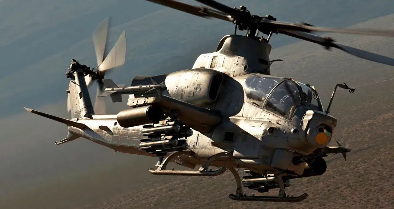 Ein Kampfhubschrauber AH-1Z Viper fliegt über eine trockene Landschaft.