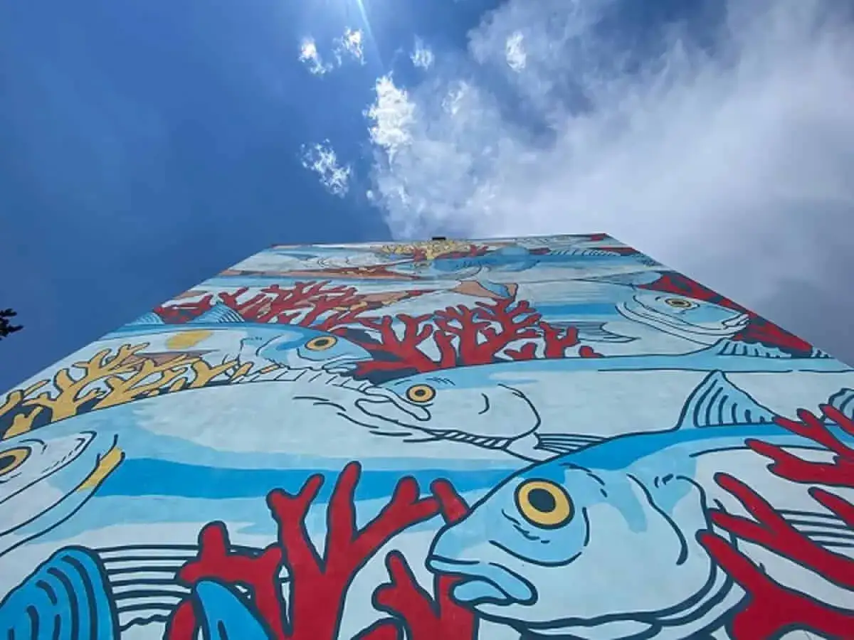 Un'onda di vita marina colorata decora un muro a Roma, un'esplosione di arte urbana che porta il mare in città.