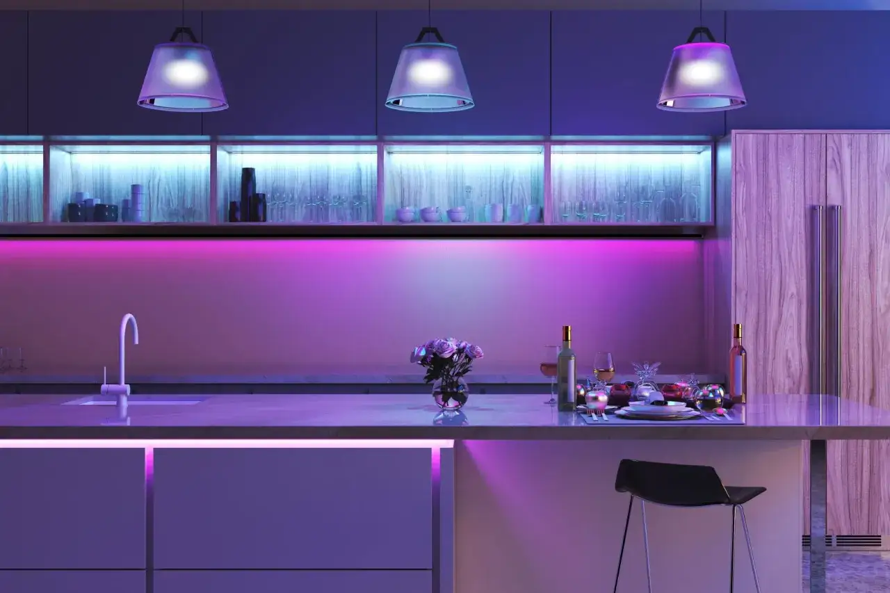 Cocina moderna con iluminación LED que potencia bombillas y crea un ambiente vibrante. Vajilla, copas y flores sobre la encimera.