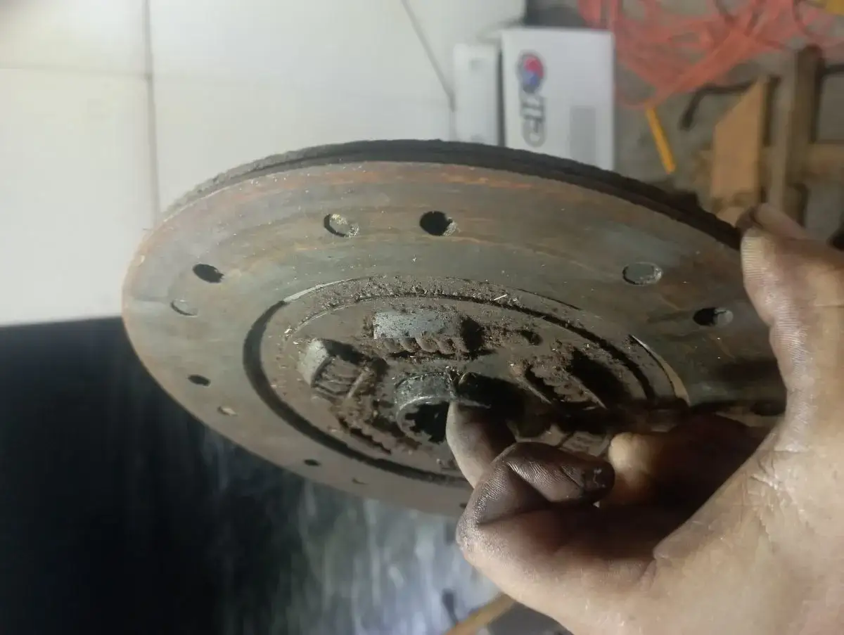 Brudna tarcza sprzęgła w dłoni mechanika. Kluczowe pytanie: montaż tarczy sprzęgła którą stroną?
