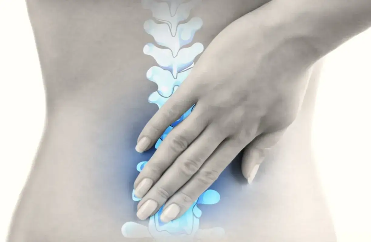 Hand berührt schmerzende Lendenwirbelsäule, die Spondylose LWS symbolisiert.