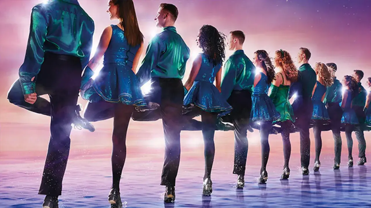 Tancerze w błyszczących, niebieskich strojach wykonują dynamiczny taniec. To niesamowity pokaz Riverdance w Polsce!
