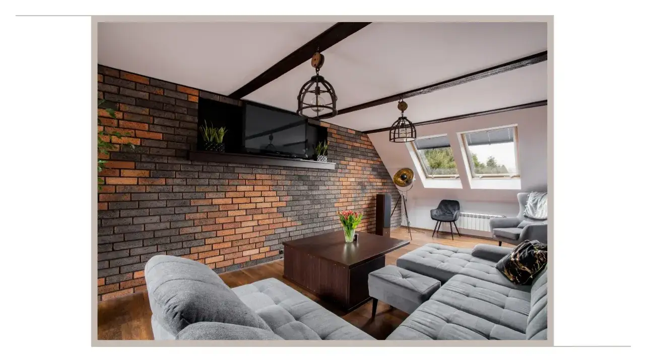 Przytulny salon w stylu loft z ceglaną ścianą, szarą sofą i drewnianym stolikiem.