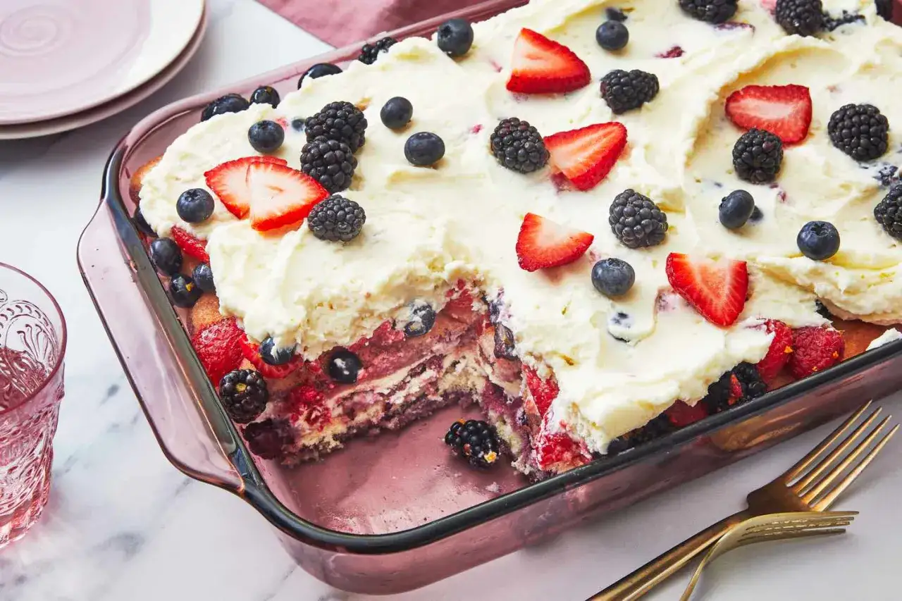 Un d&eacute;licieux tiramisu fruits, garni de fraises, myrtilles et m&ucirc;res, dans un plat en verre rose.