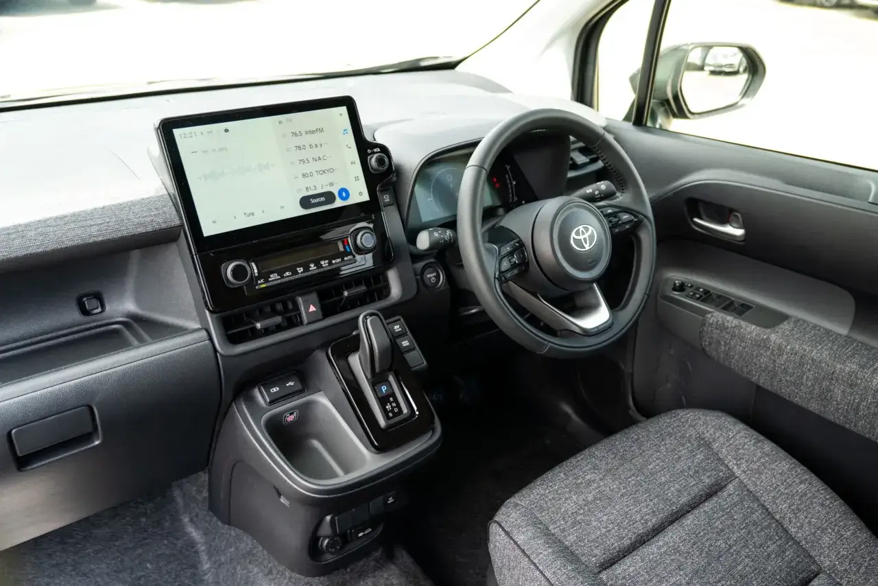 Interi&ouml;r i en Toyota Sienta med stor peksk&auml;rm, ratt och automatisk v&auml;xell&aring;da.