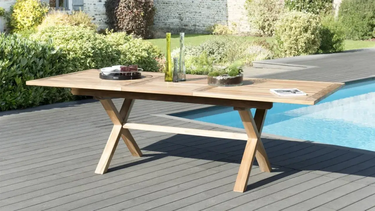 Table en teck, mati&egrave;re noble et r&eacute;sistante, pr&ecirc;te pour un repas ensoleill&eacute; au bord de la piscine.