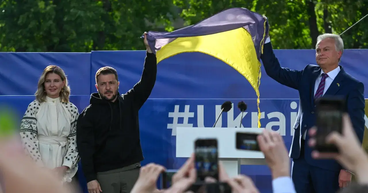Prezydent Litwy Gitanas Nausėda i prezydent Ukrainy Wołodymyr Zełenski trzymają ukraińską flagę.