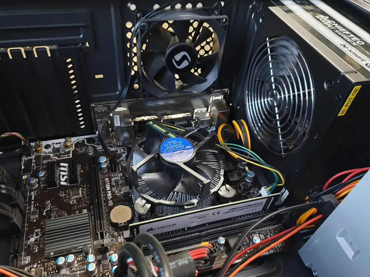 Wnętrze komputera, gdzie komputer sam się resetuje. Widać płytę główną MSI, procesor Intel, pamięć RAM Corsair i zasilacz Chieftec.