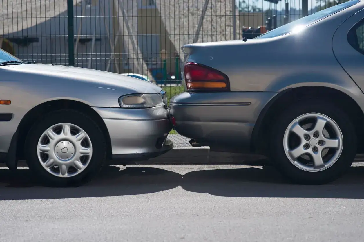 Deux voitures argent&eacute;es se touchent au pare-chocs, un sc&eacute;nario qui pourrait n&eacute;cessiter une assurance parking voiture.